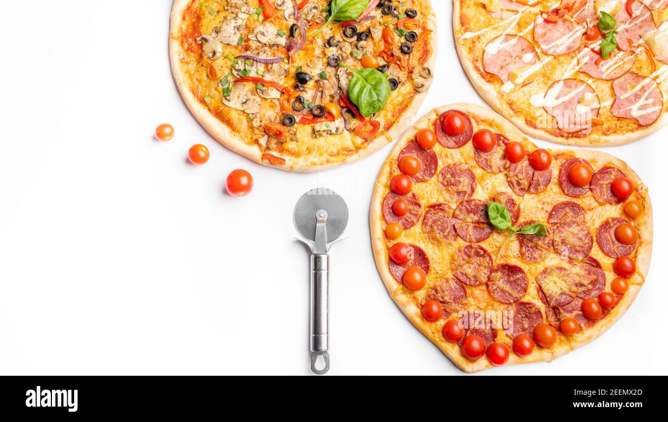 Drei verschiedene Arten von Pizzen, rund und Herz auf weißem Hintergrund mit Kopierraum, Salami, Pilze, Tomaton, Pepperoni, Kirschtomate und Stockfoto