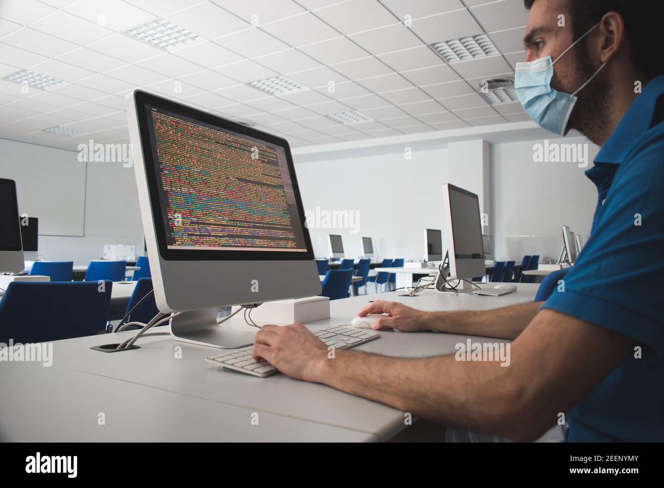 Mann, der einen Computer in einer Klasse benutzt Stockfoto