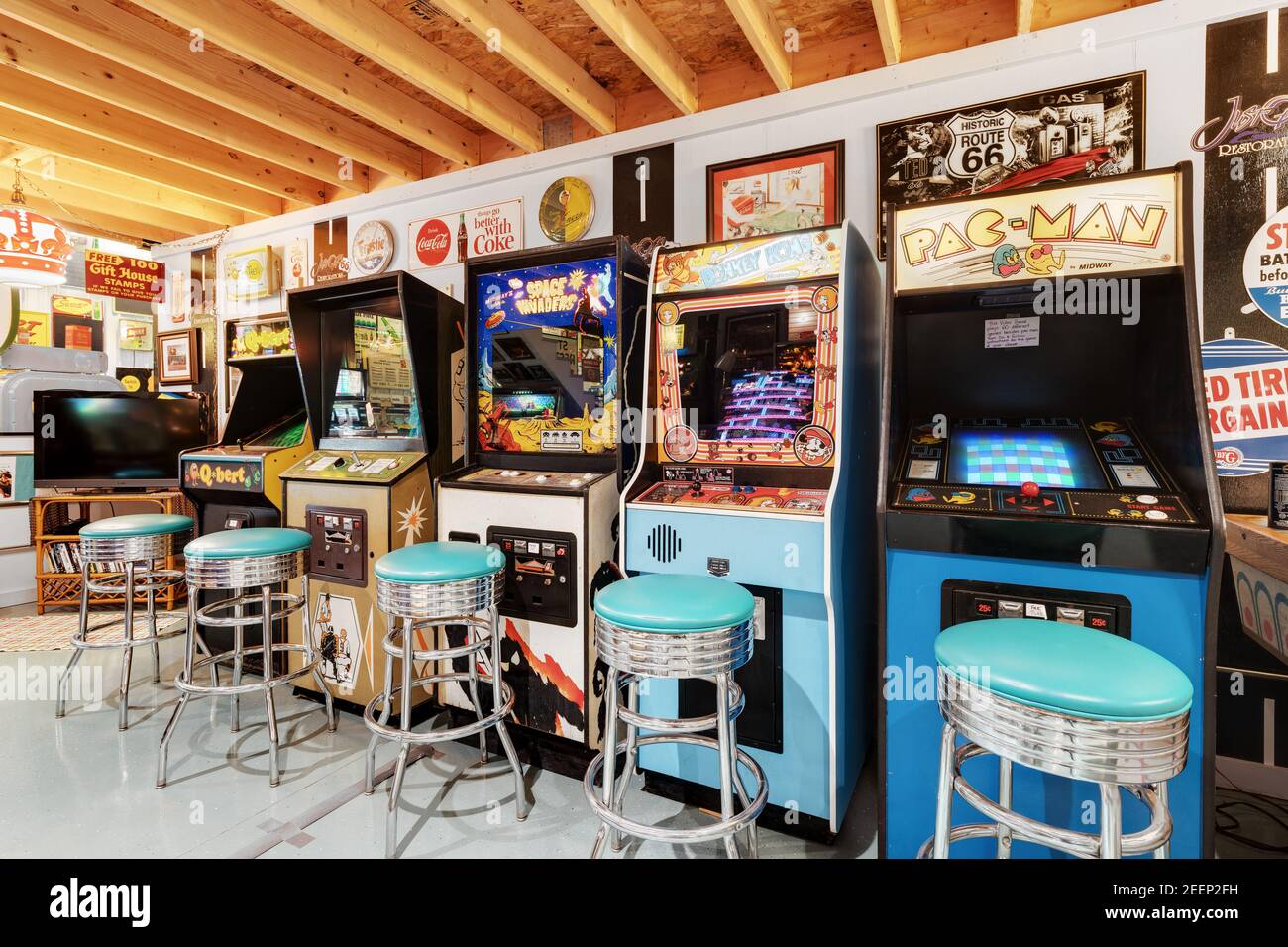 Eine Kellerhalle mit verschiedenen Retro-Flipper und klassischen Arcade-Spielen, alten Stahl- und Blechschildern und vielen Sitzgelegenheiten. Stockfoto