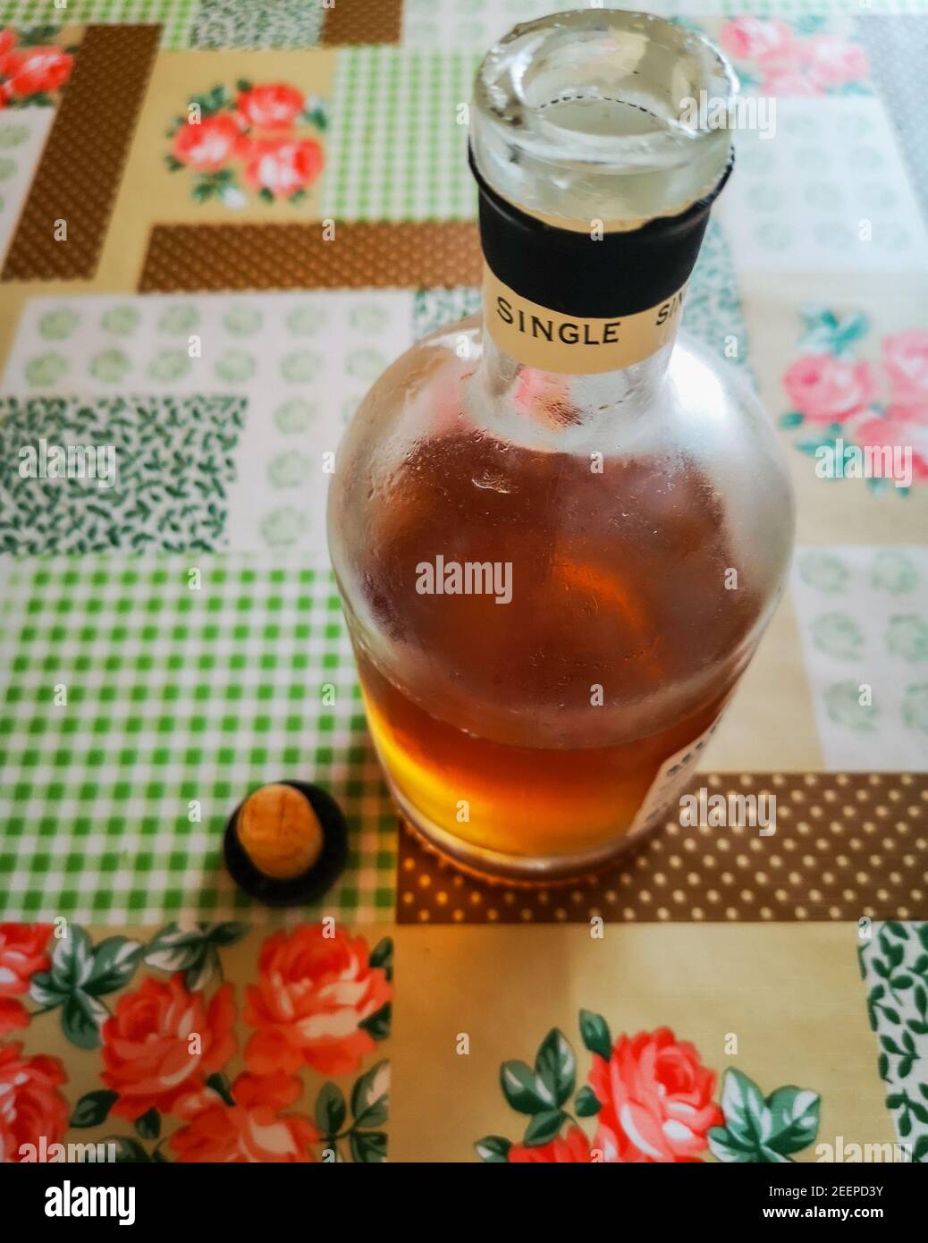 Halb volle Flasche Whisky und buntes Öltuch aufstopfen Stockfoto