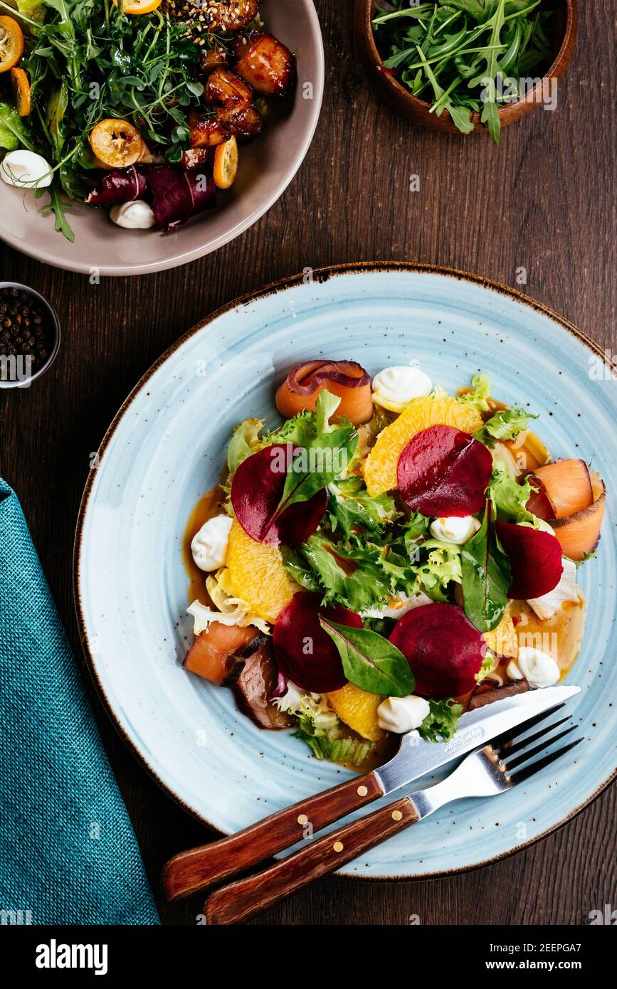 Draufsicht auf Salat mit Lachs, Rettich, Zucchini und Rote Beete auf Holztisch Stockfoto