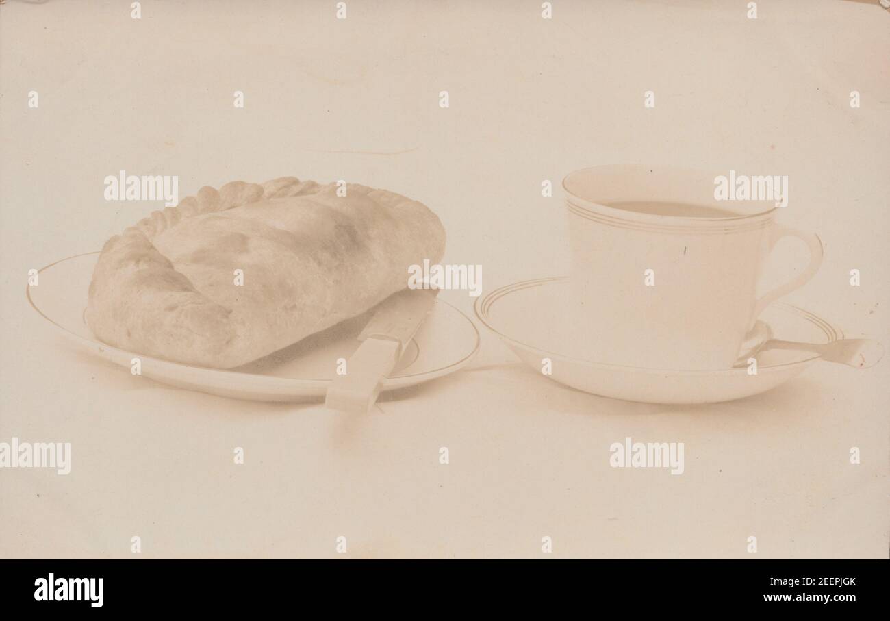 Jahrgang Anfang 20th Jahrhundert Fotopostkarte zeigt eine kornische Pasty und eine Tasse Tee. Stockfoto