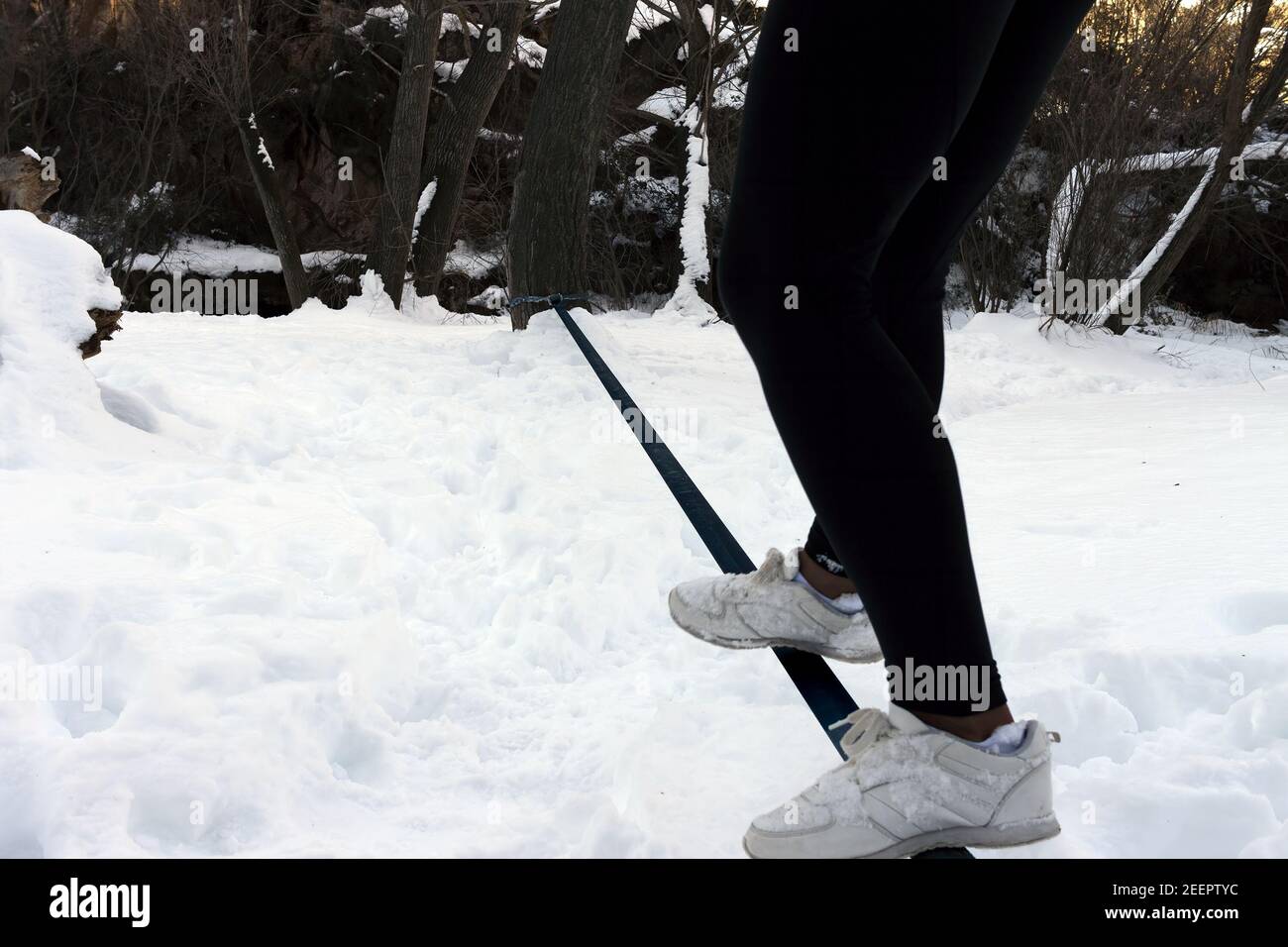 Ein junger Teenager balanciert eine Gratwanderung im Schnee Stockfoto