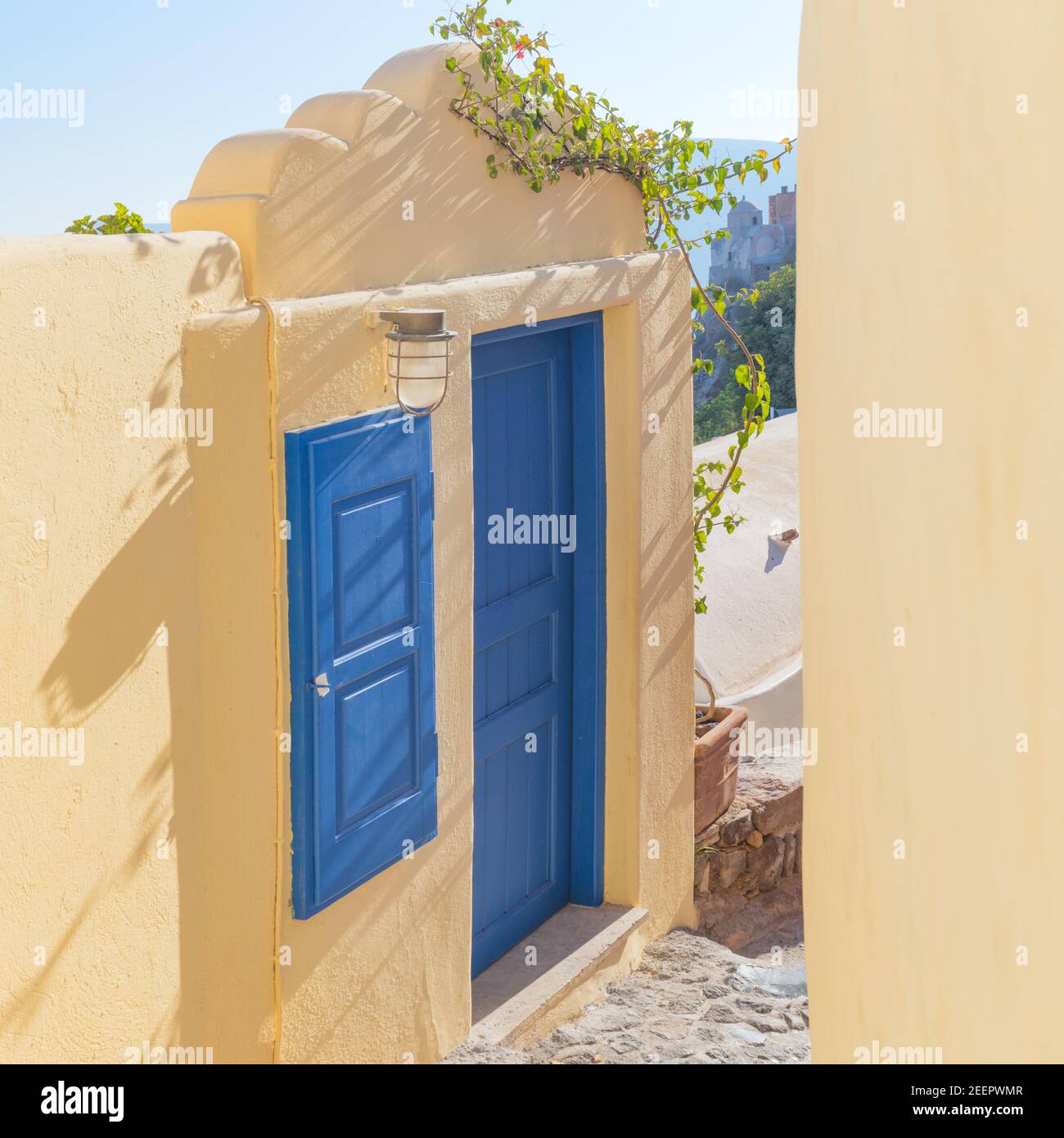 Alte blaue Tür und Fenster in der engen Straße. Konzeptuelle künstlerische Fragmente traditioneller Gebäude in Oia auf Santorini. Ein malerischer Blick auf den t Stockfoto