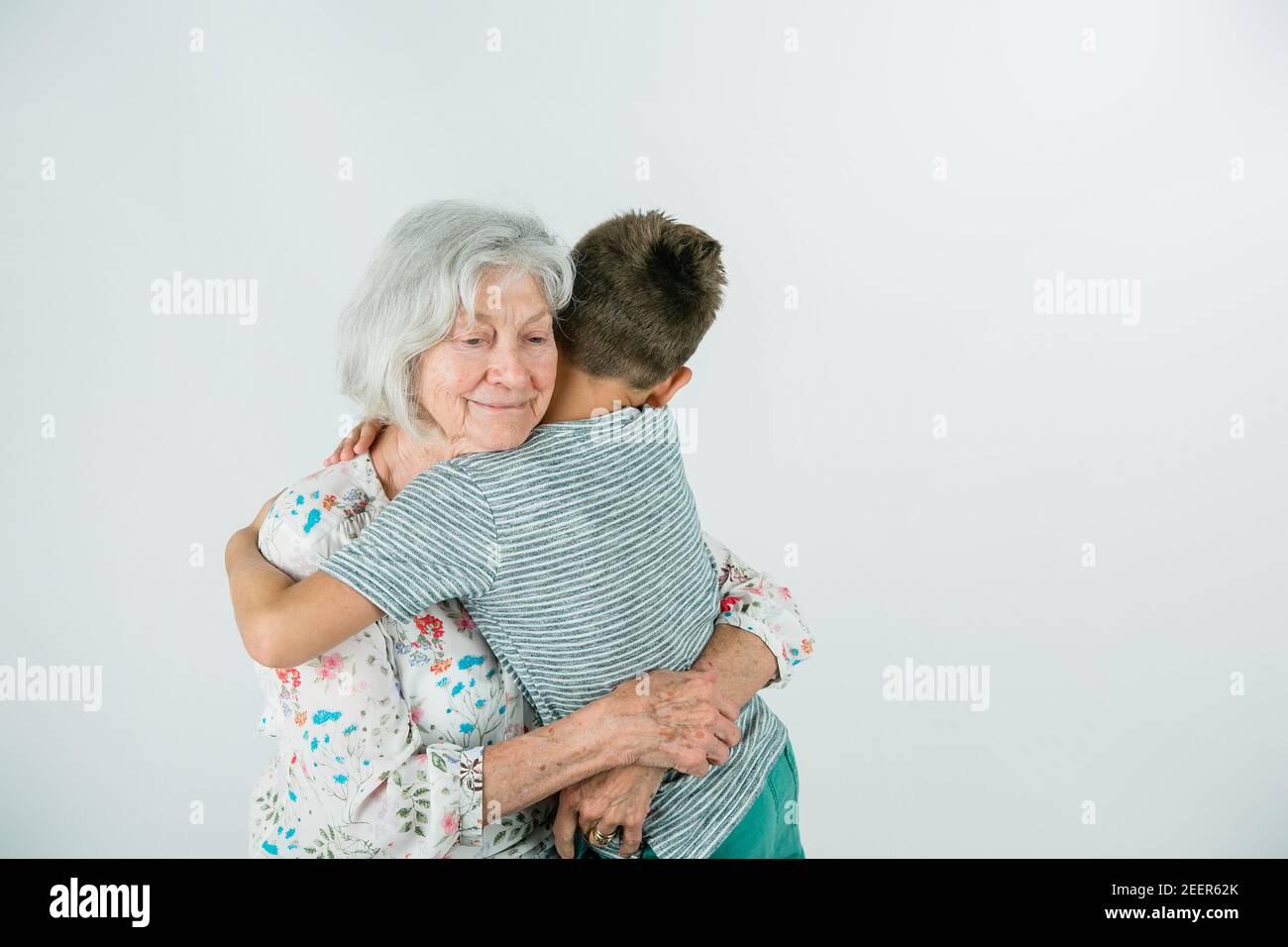 Eine Großmutter und ein Enkel auf einer weißen Studiokulisse Stockfoto