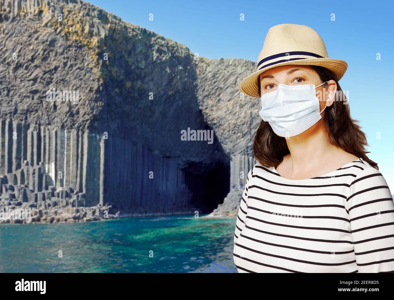 Reisen während der Corona oder covid Pandemie: Frau Tourist trägt Schutzmaske in Staffa, Hebrides, Schottland. Stockfoto