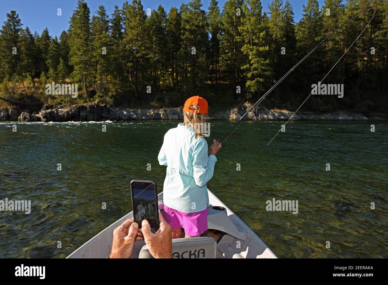 Joanne Linehan hakt eine große Forelle, während ihr Mann Tim ein Handy-Foto auf dem Kootenai River macht. Lincoln County, MT. (Foto von Randy Beacham) Stockfoto