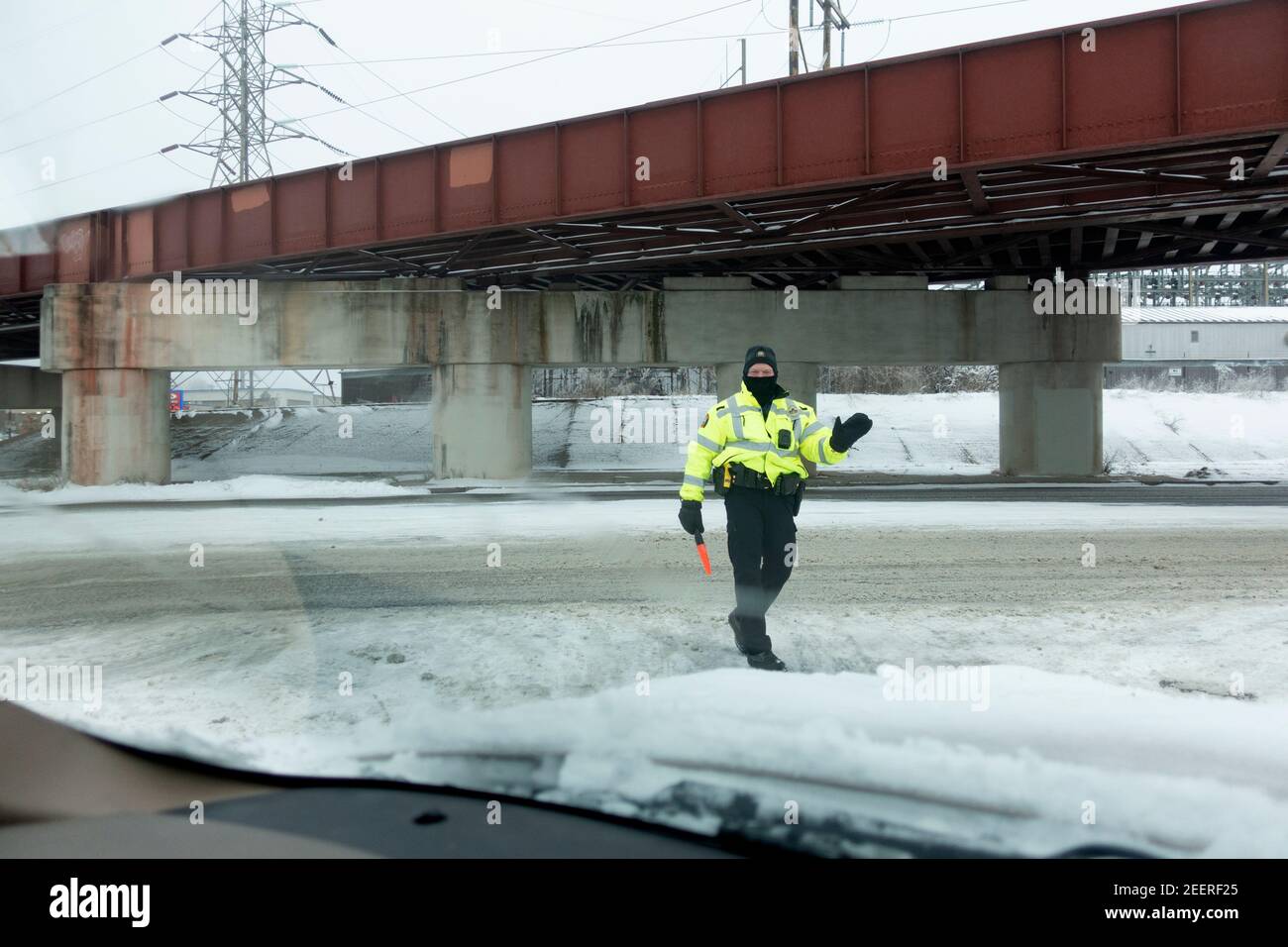 Maskierter Polizist, der während der Corona Pandemie den Verkehr am Starbucks Drive-Thru lenkt. St. Paul Minnesota, USA Stockfoto