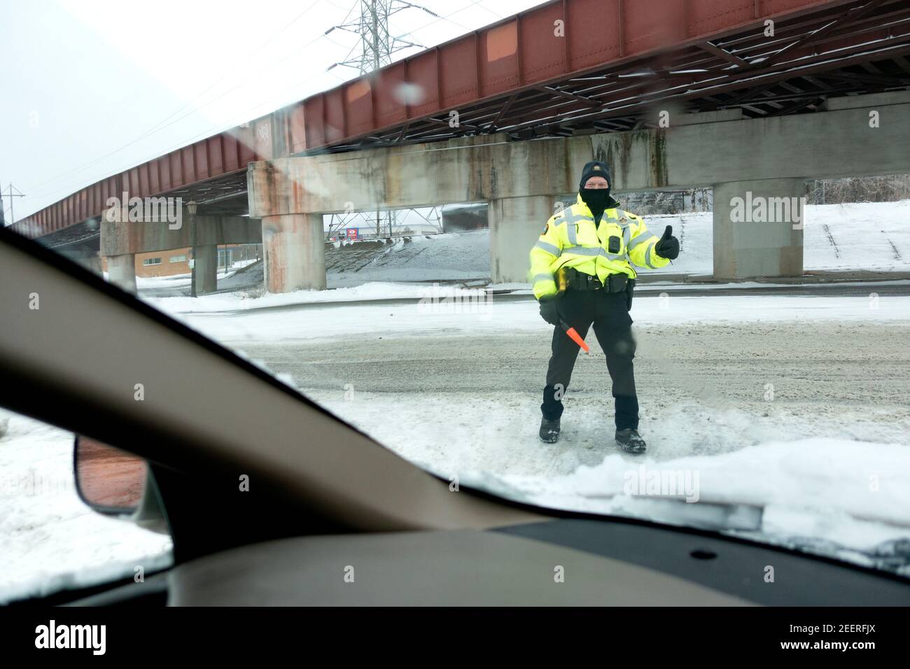 Polizeibeamte maskierten die Daumen nach oben und lenkten den Verkehr im Starbucks Drive-Thru Kaffeehaus. St. Paul Minnesota, USA Stockfoto