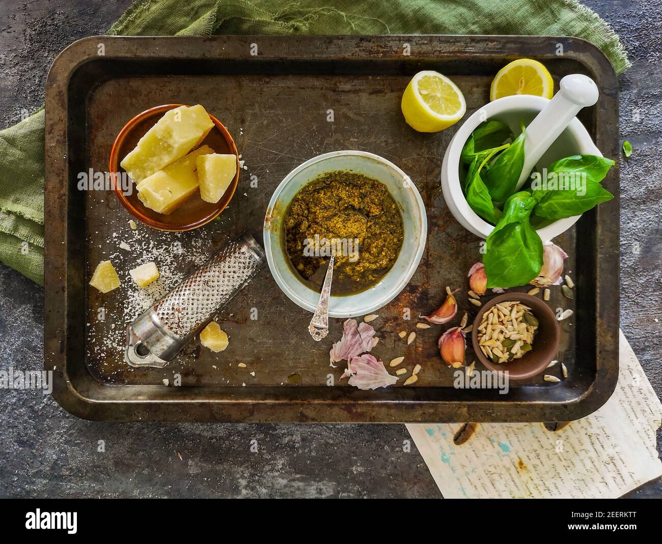 Grünes Pesto, Basilikum im Mörser, Parmesankäse, Knoblauch auf Metallschale Stockfoto