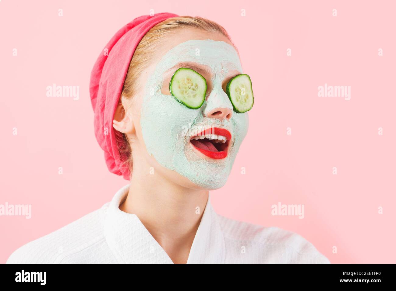 Frau mit kosmetischer Maske im Gesicht. Gurkenscheiben auf den Augen. Frau mit Gesichtsmaske. Schönheitsbehandlung. Spa-Therapie. Stockfoto