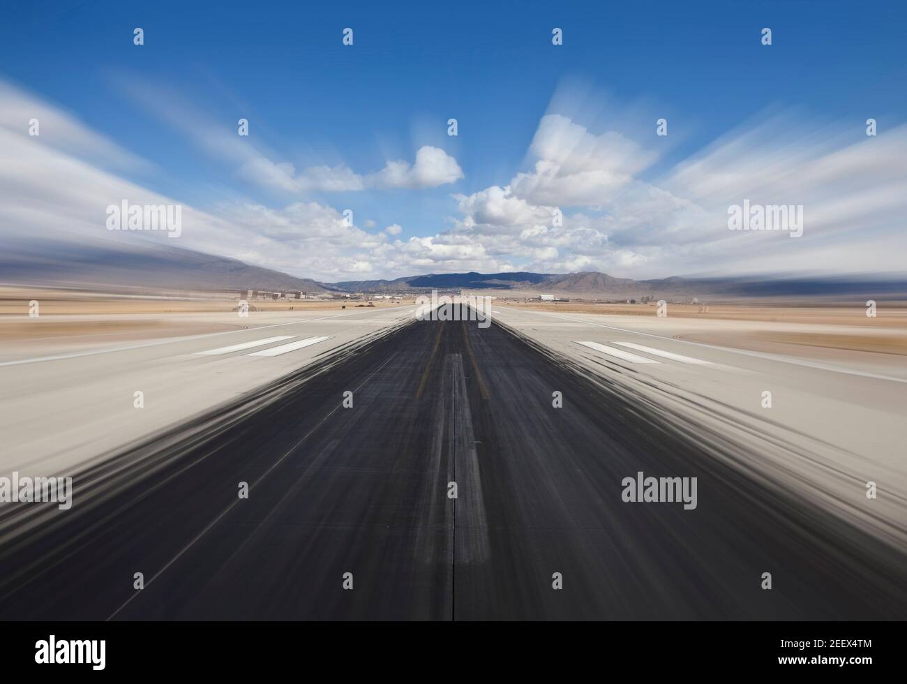 Wüste Flughafen Start- und Landebahn mit dunklen Rutschmarken und Bewegungsunschärfe. Stockfoto