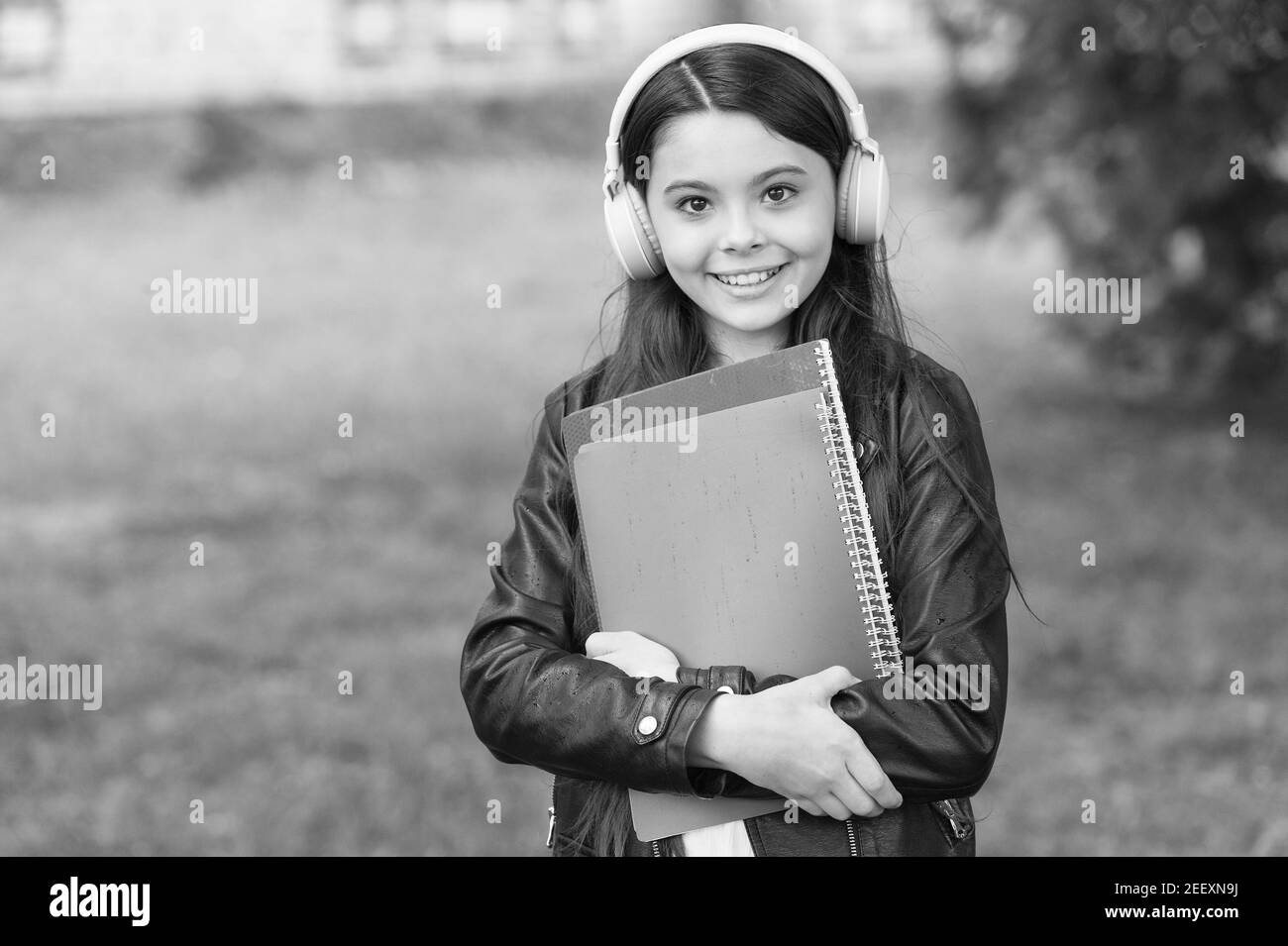 Mädchen hören Audio tragen Lehrbücher auf dem Weg zur Schule, Schule Club Konzept. Stockfoto
