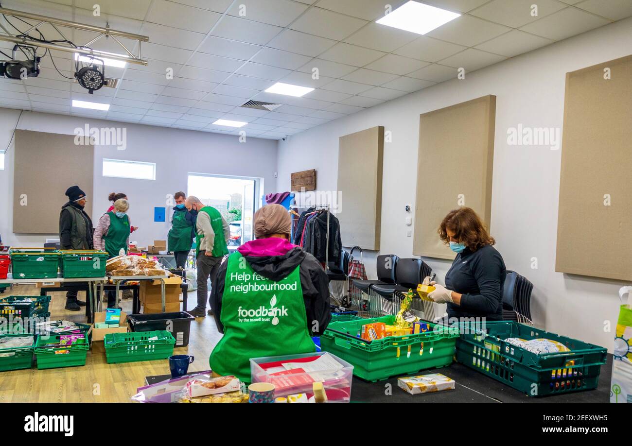 Freiwillige bei einer Trussell Trust Foodbank sammeln, sortieren und organisieren gespendete Lebensmittel, die an die lokale Gemeinschaft in Colindale UK gegeben werden Stockfoto