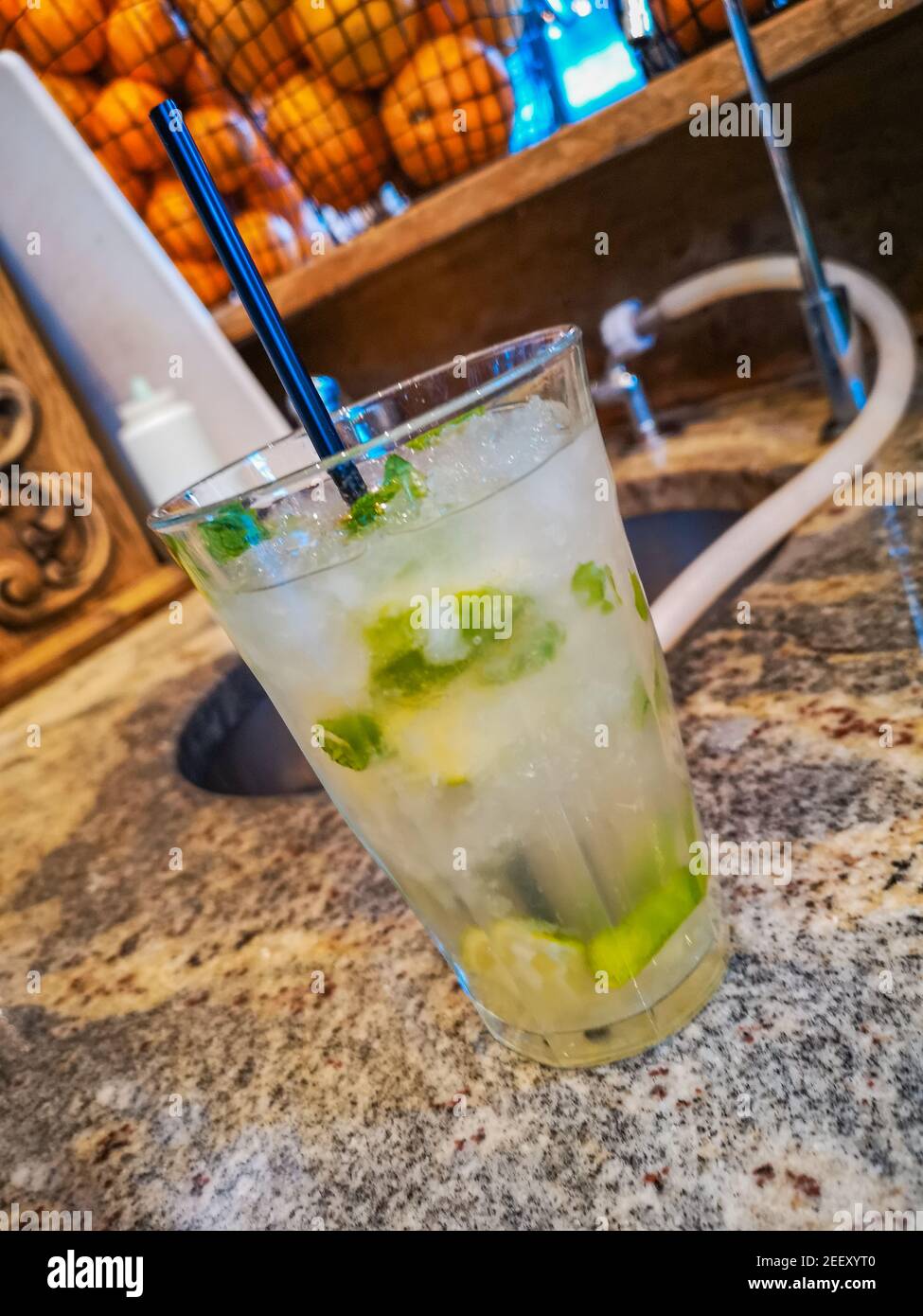 Mojito trinken in hohem Glas mit zerdrücktem Eis hinter gefüllt Bar Stockfoto