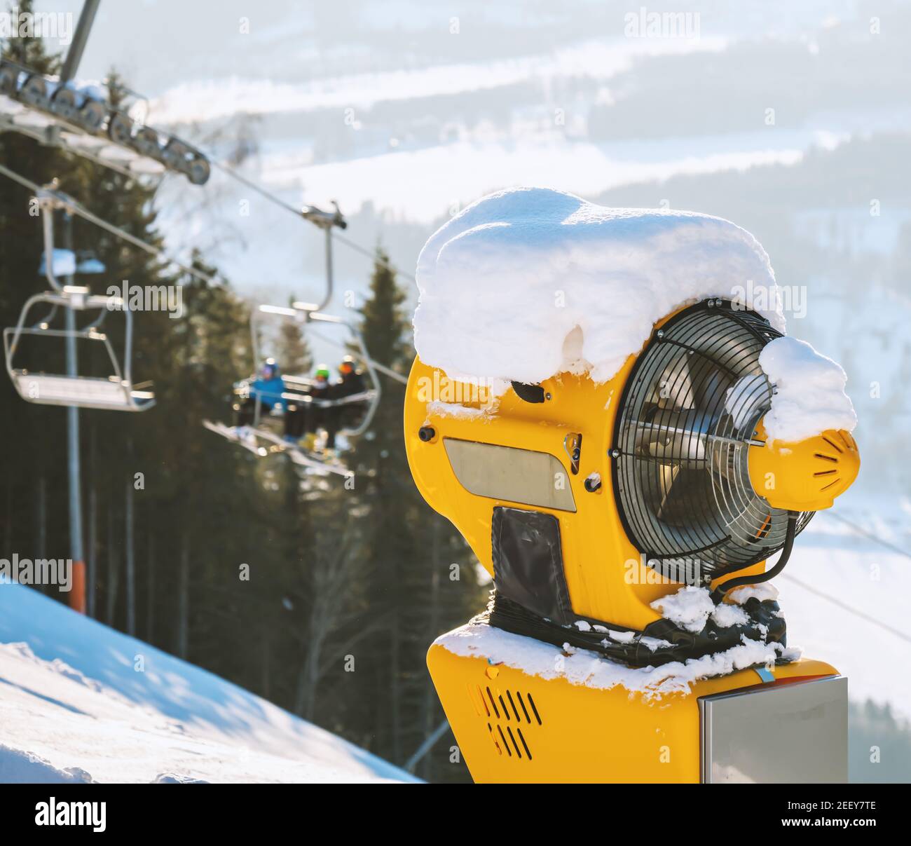An einem sonnigen Wintertag wird in einem Skigebiet eine Maschine für die Beschneiung gemacht. Stockfoto