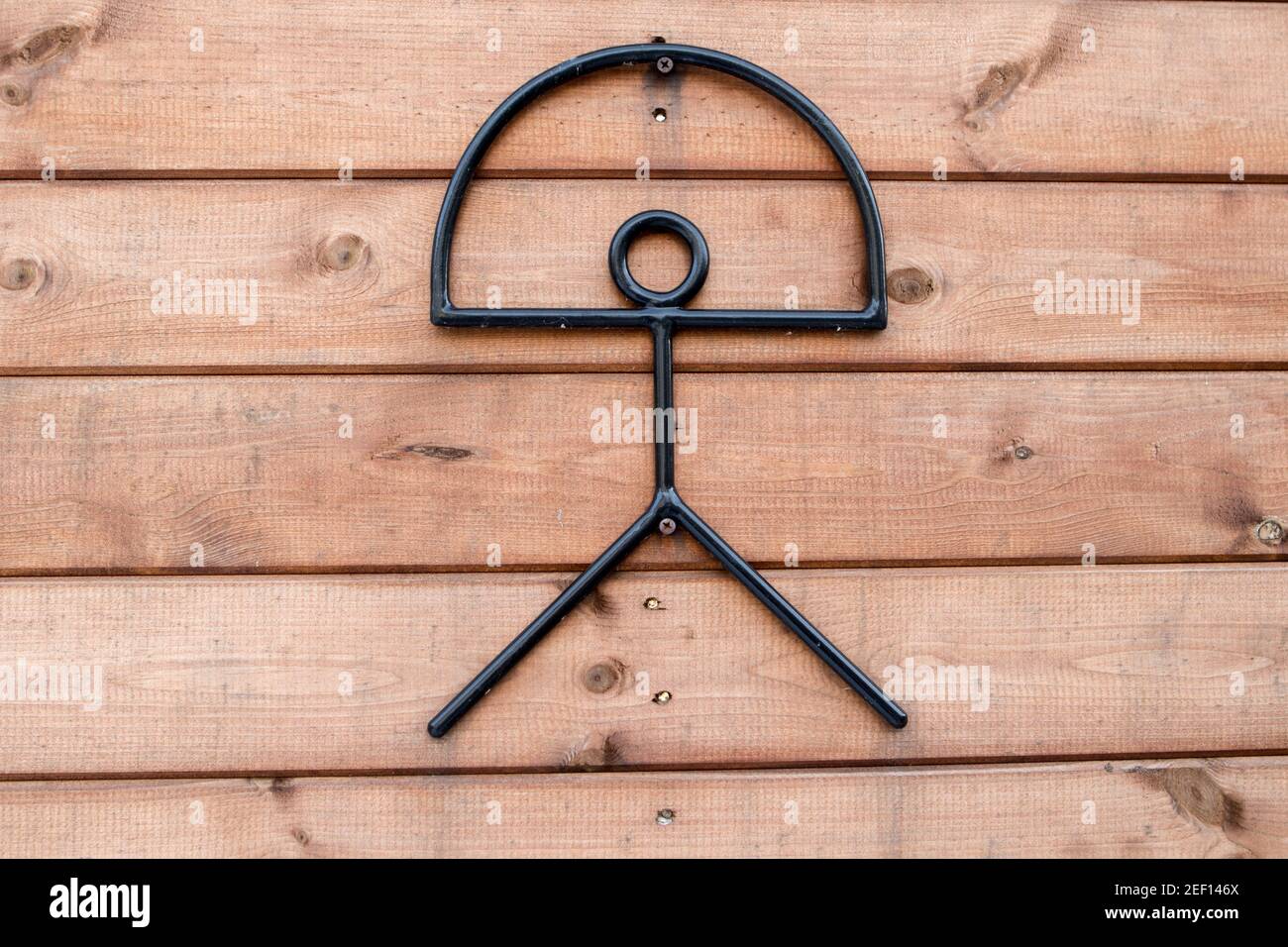 Metall-Indalo-Mann-Symbol an einem Holzzaun. Der Indalo ist ein uraltes Glückssymbol und wird als ein Knüppel dargestellt, der einen Regenbogen hält. Stockfoto