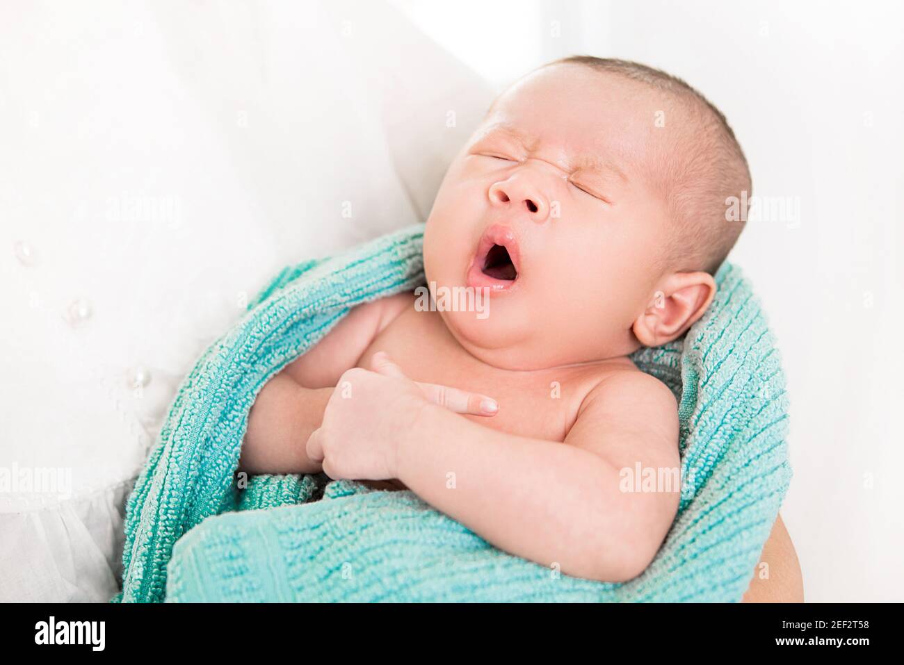 Liebenswert neugeborenes Baby gähnend während schlafen in den Armen von Mutter Stockfoto