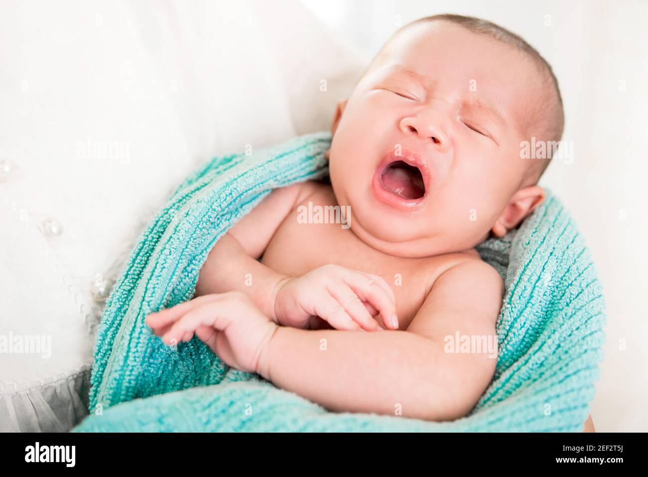 Liebenswert neugeborenes Baby weint in den Armen der Mutter, während Schlafen gehen Stockfoto