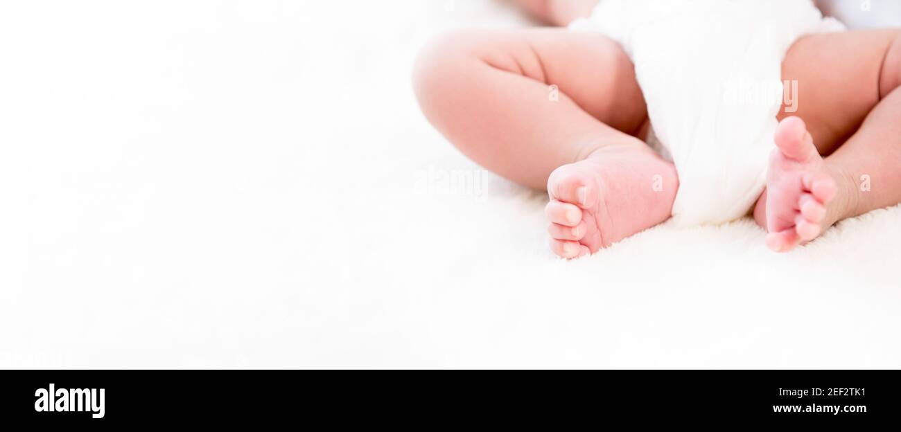 Baby Beine und Füße auf weißem Wollflusentuch - Panorama-Webbanner mit Kopierbereich Stockfoto
