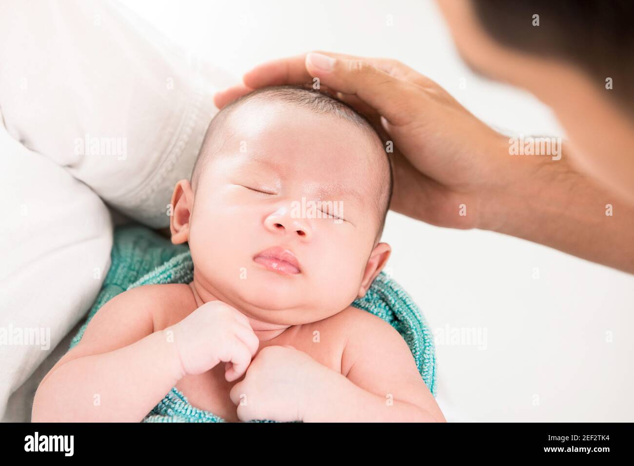 Vater Hand berühren Kopf des schlafenden Babys mit Sorgfalt Stockfoto