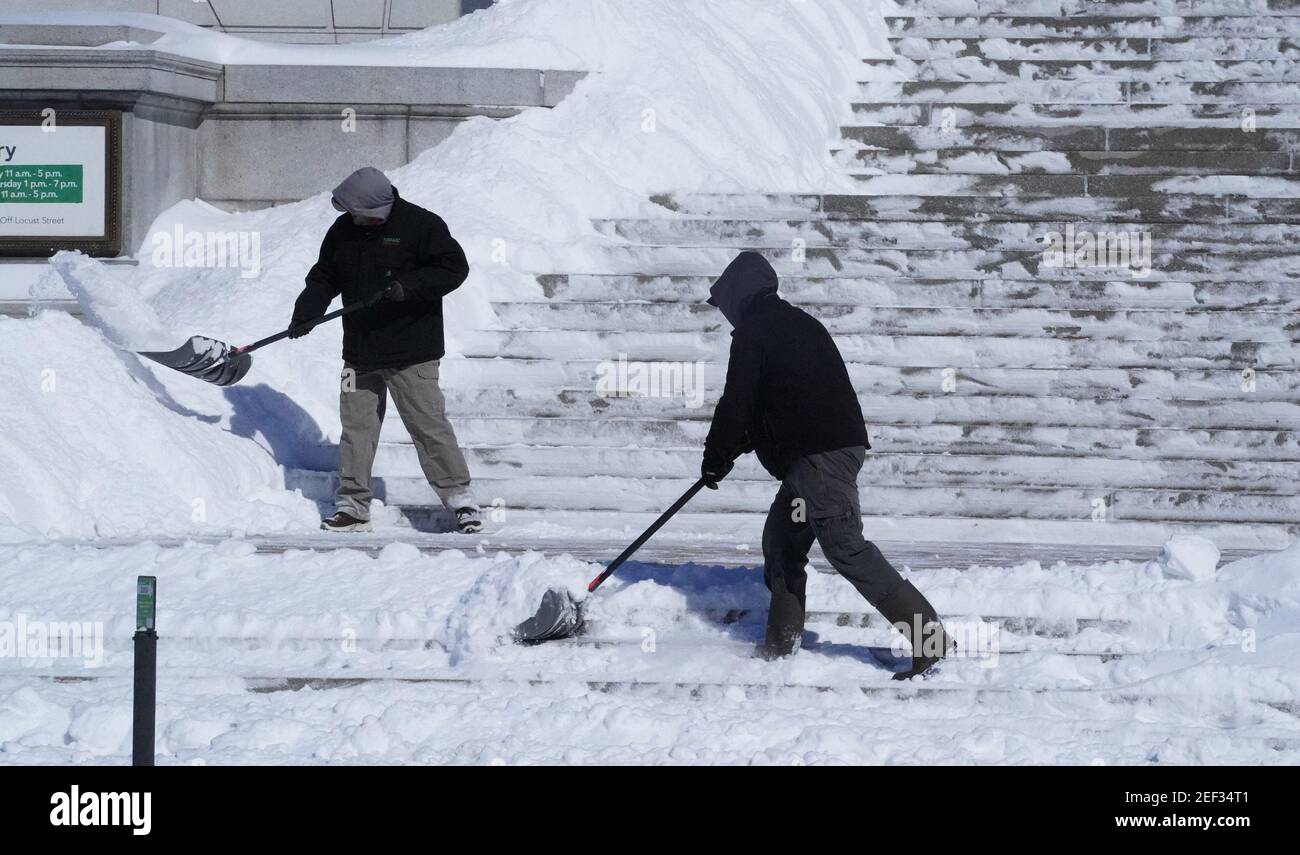 St. Louis, Usa. Februar 2021, 16th. Am Dienstag, den 16. Februar 2021, räumen Männer 8 cm Schnee von der Haupttreppe der St. Louis-Bibliothek in der Innenstadt von St. Louis. Foto von Bill Greenblatt/UPI Kredit: UPI/Alamy Live News Stockfoto