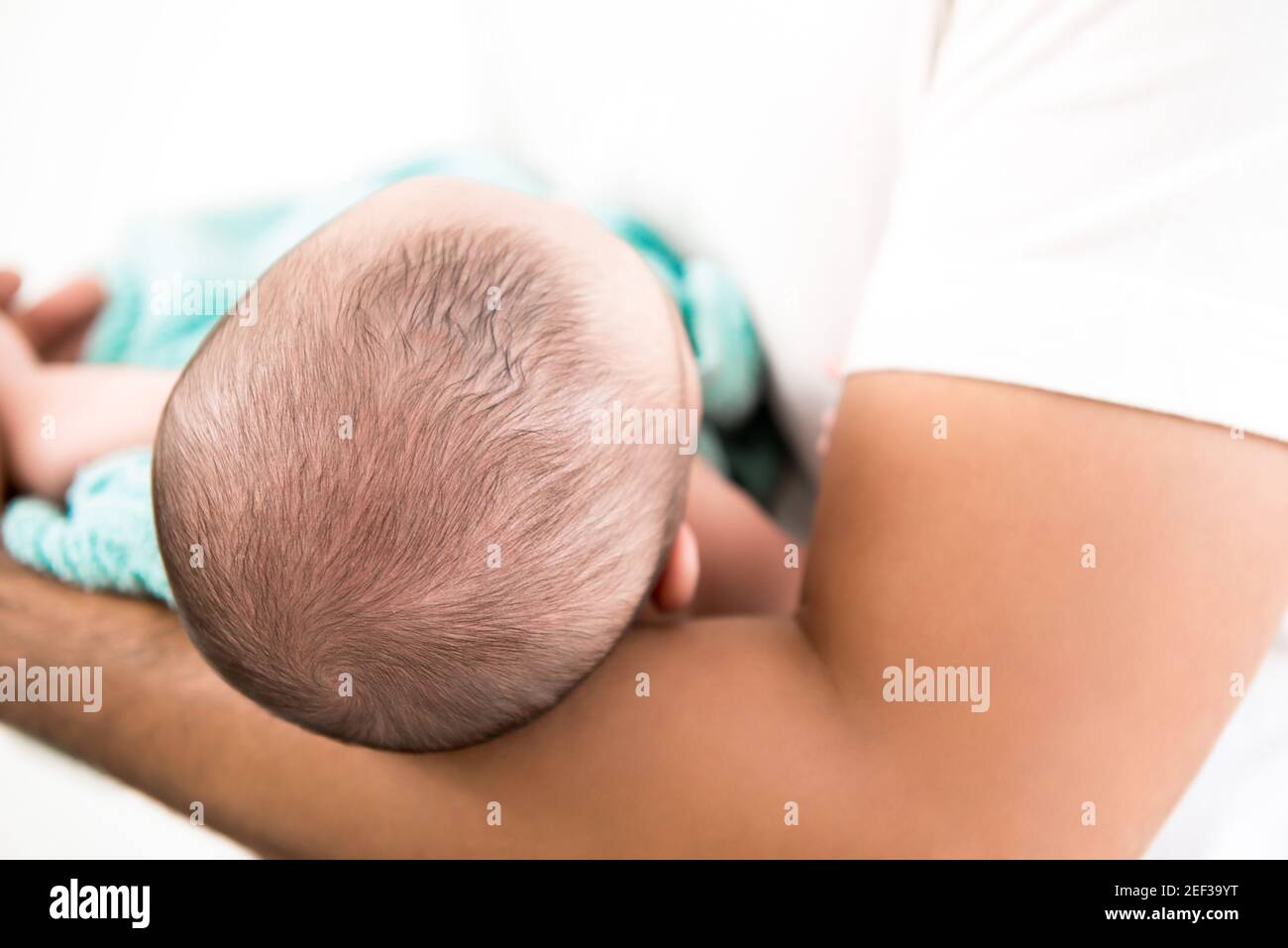 Kopf des Neugeborenen im Vaterarm Stockfoto