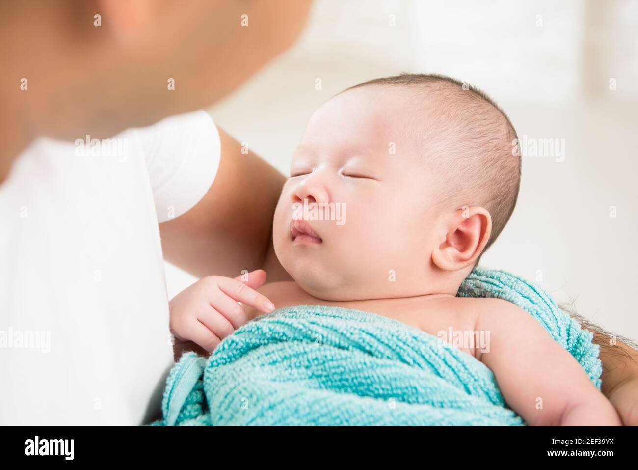 Liebenswert neugeborenes Baby schlafen in den Armen des Vaters Stockfoto