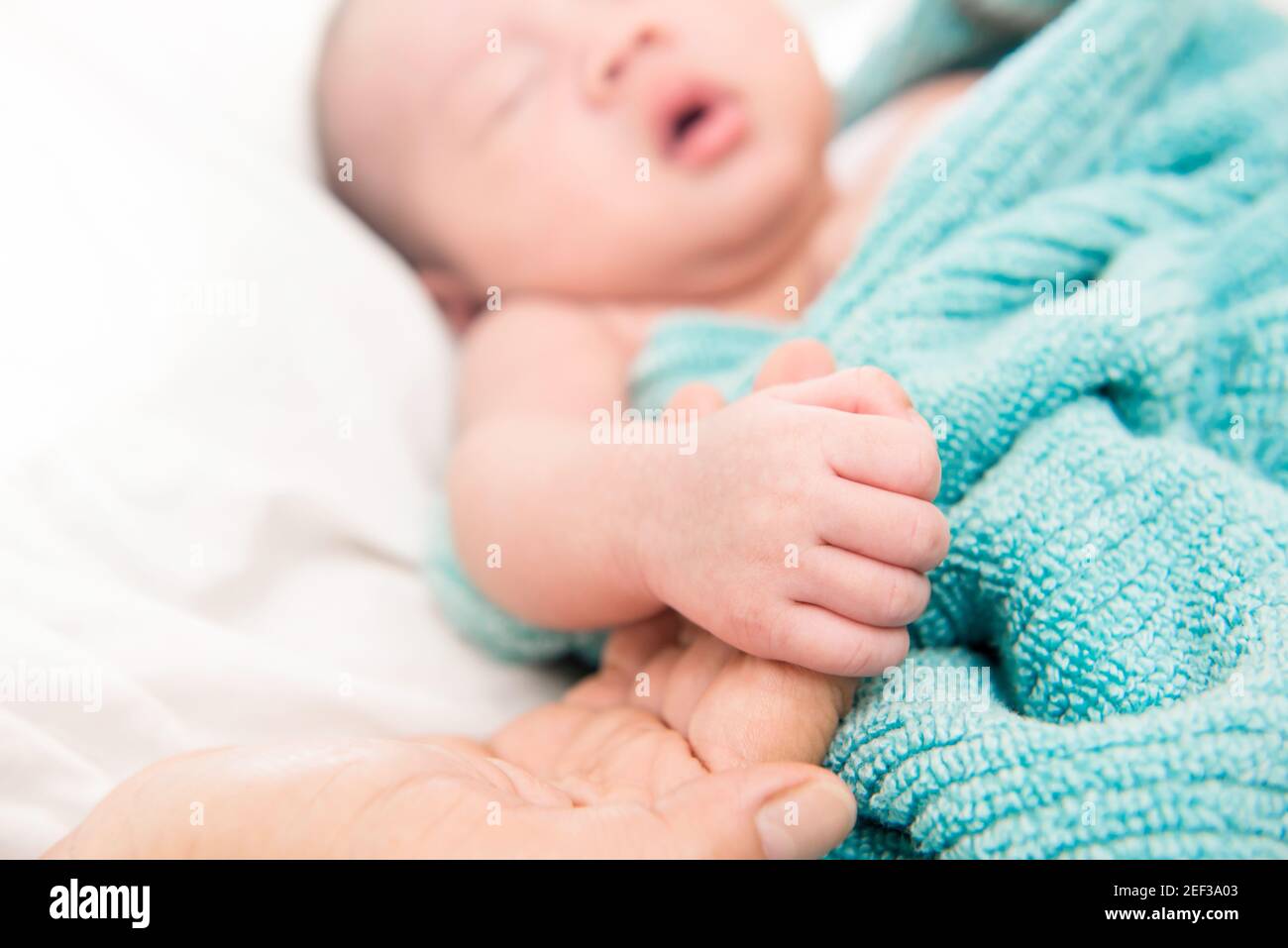 Niedliche schlafen Baby Hand des Vaters halten Stockfoto