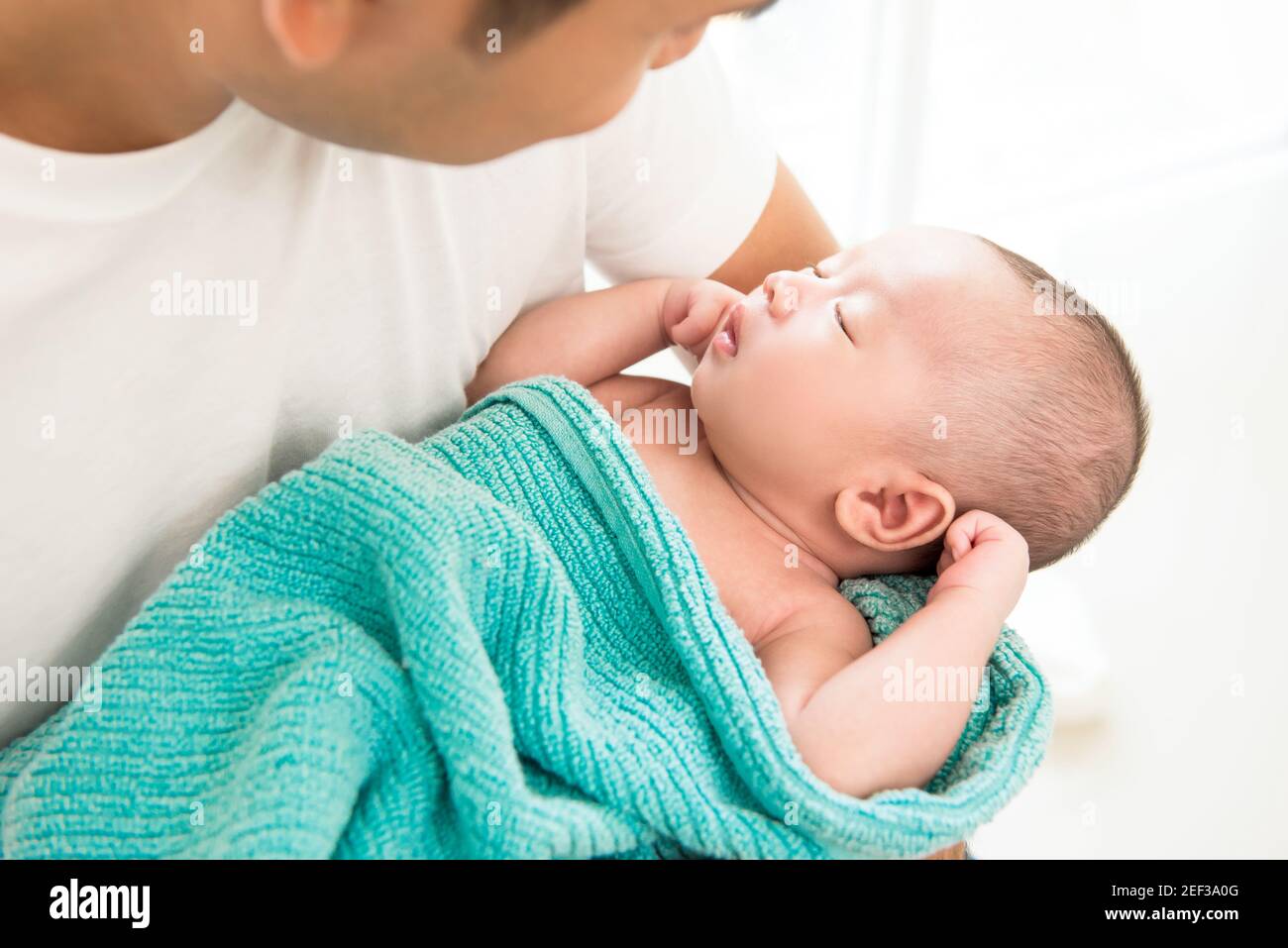 Liebenswert neugeborenes Baby schlafen in den Armen des Vaters Stockfoto