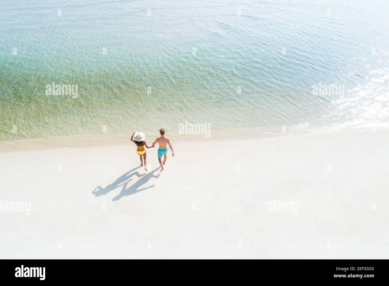 Pärchen, die am Strand ins Meerwasser laufen - Vogelauge Anzeigen Stockfoto Pärchen, die am Strand ins Meerwasser laufen - Vogelauge Anzeigen Stockfoto