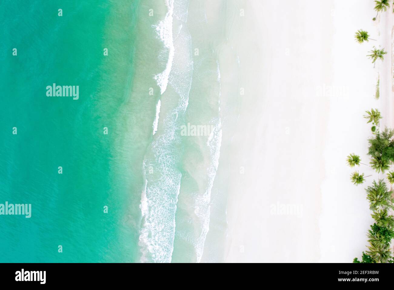 Draufsicht auf schönen weißen Sandstrand mit türkisfarbenem Meerwasser und Palmen, Luftdrohne erschossen Stockfoto