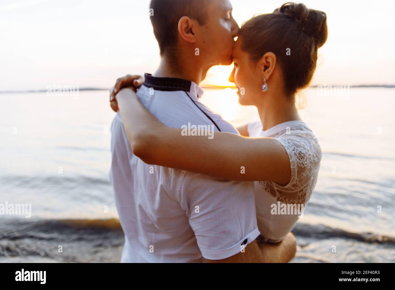 Vage Silhouetten eines Mannes und einer Frau. Ein Mann küsst seine Herrin auf die Stirn Stockfoto
