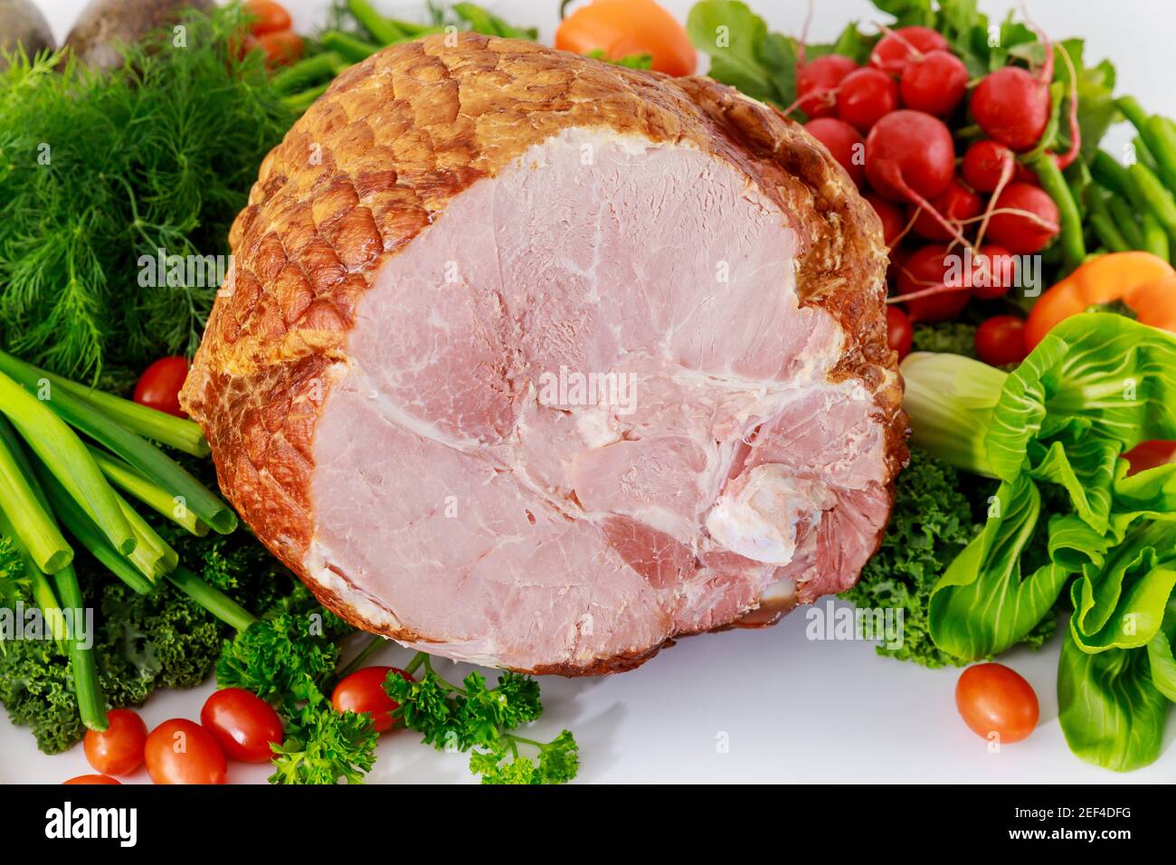 Geräucherter Vollschinken mit gesundem frischem Gemüse. Stockfoto