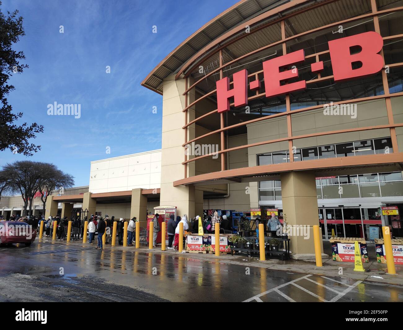 Austin, Texas - 15. Februar 2021: Eine lange Schlange umwickelt einen HEB-Supermarkt mit Schnee draußen Stockfoto
