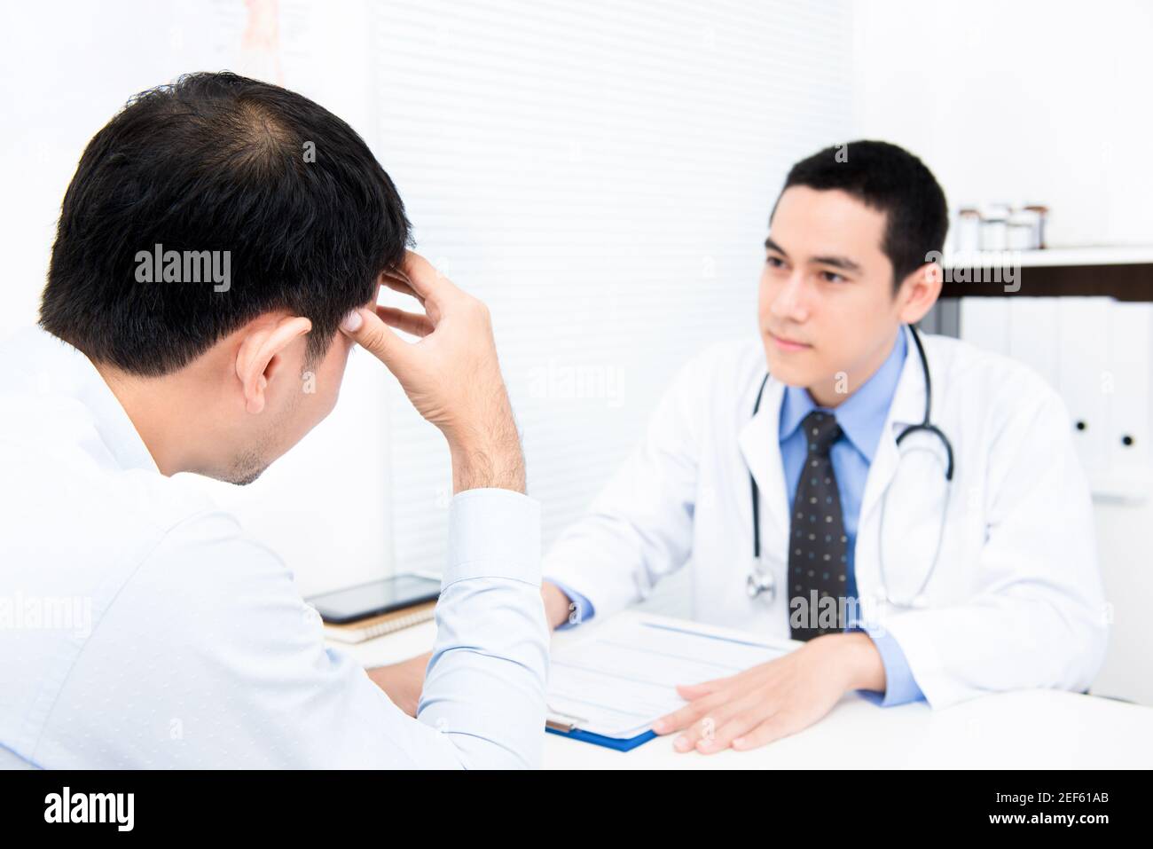 Männliche Patienten Beratung mit Arzt im Büro Stockfoto