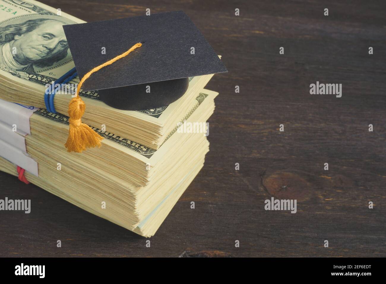 Einsparungen für Bildung und Hochschulkonzept. Geldstapel und Abschlusskappe. Stockfoto