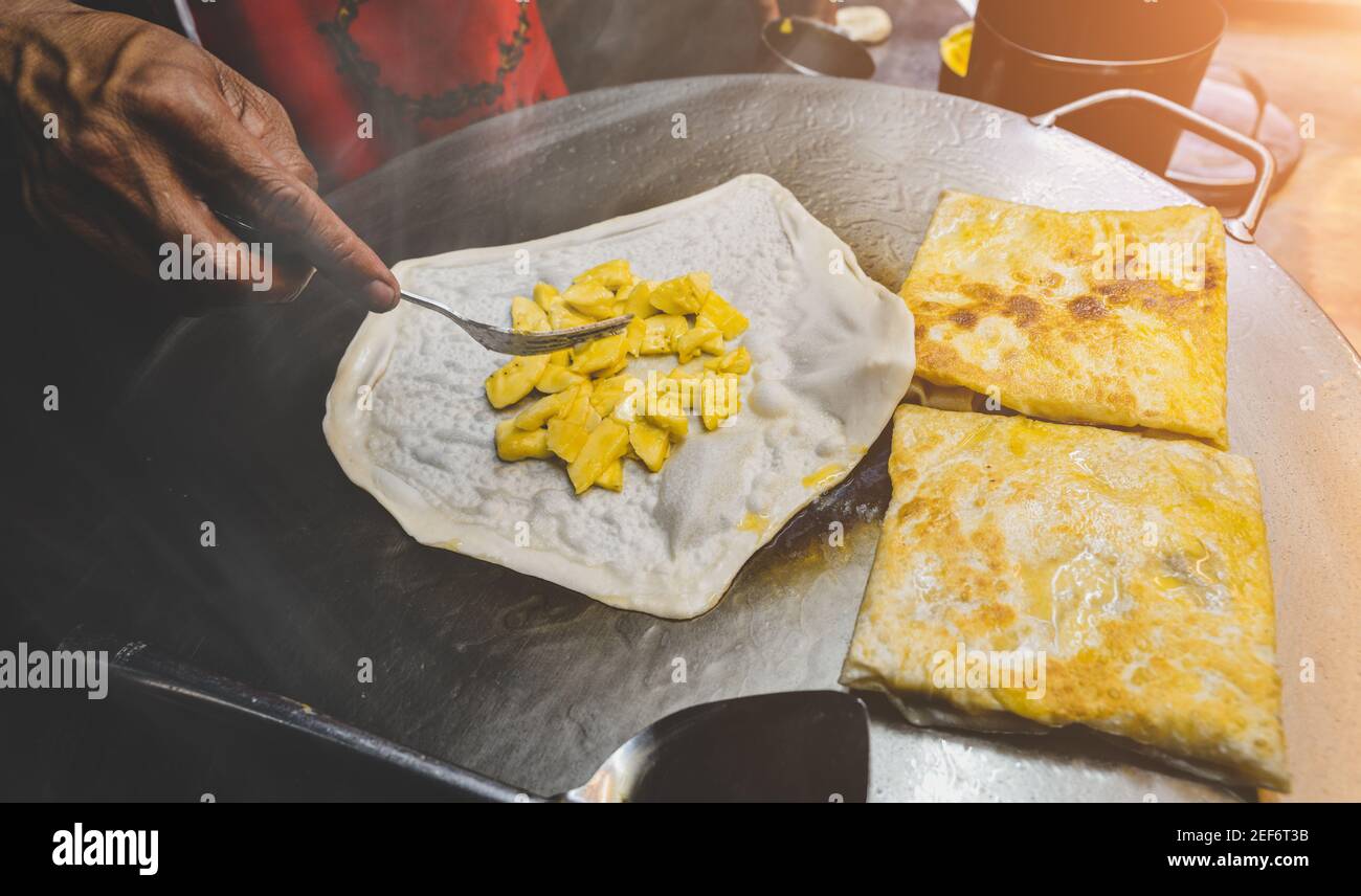 Indische Straßennahrung roti süßer Snack auf dem eisernen Teller mit Nachtbeleuchtung. Stockfoto