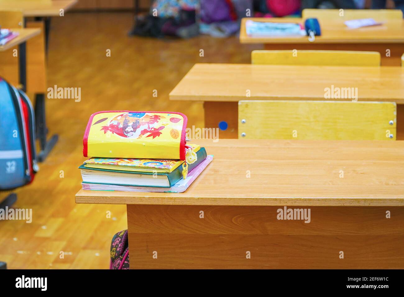 Ein Schreibtisch im Klassenzimmer mit Lehrbüchern und Notizbüchern Ein kleiner Haufen Stockfoto