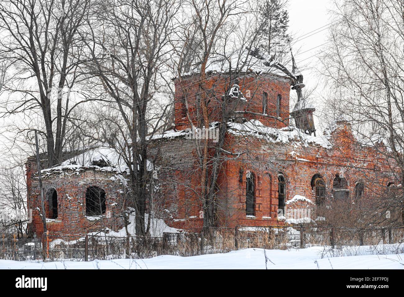 Alte steinerne Kirchenfenster im alten russischen Stil. Vintage Wände einer Kirche mit abblätternden Ziegeln in Russland Stockfoto