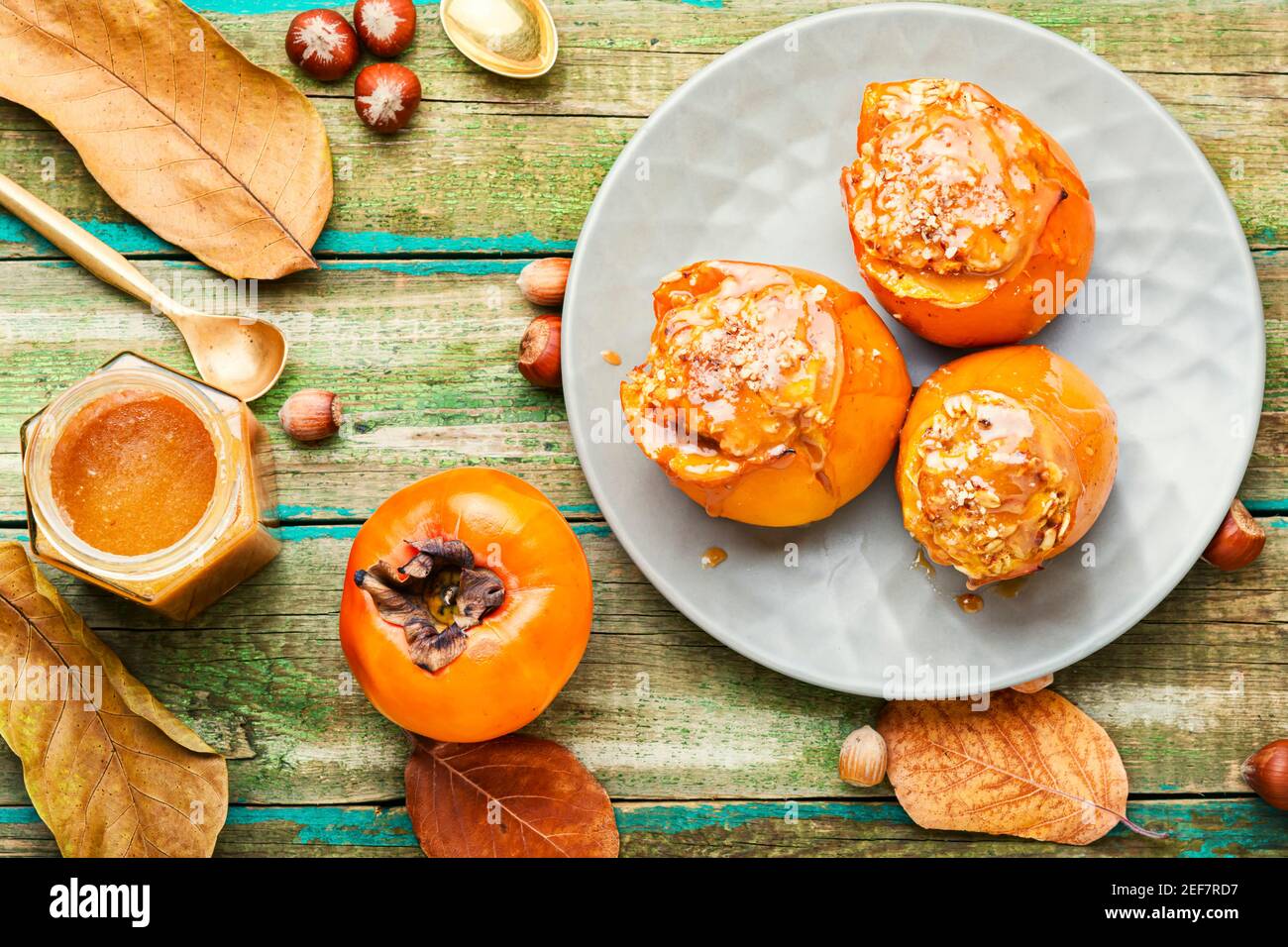 Persimmon gefüllt mit Haferflocken mit Karamellsauce.gebackene Persimmon.Herbst Dessert. Stockfoto