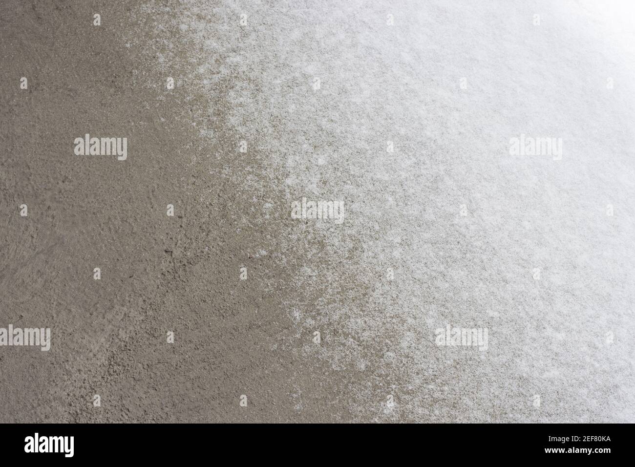 Eine dünne Schneeschicht auf dem Betondeck. Stockfoto