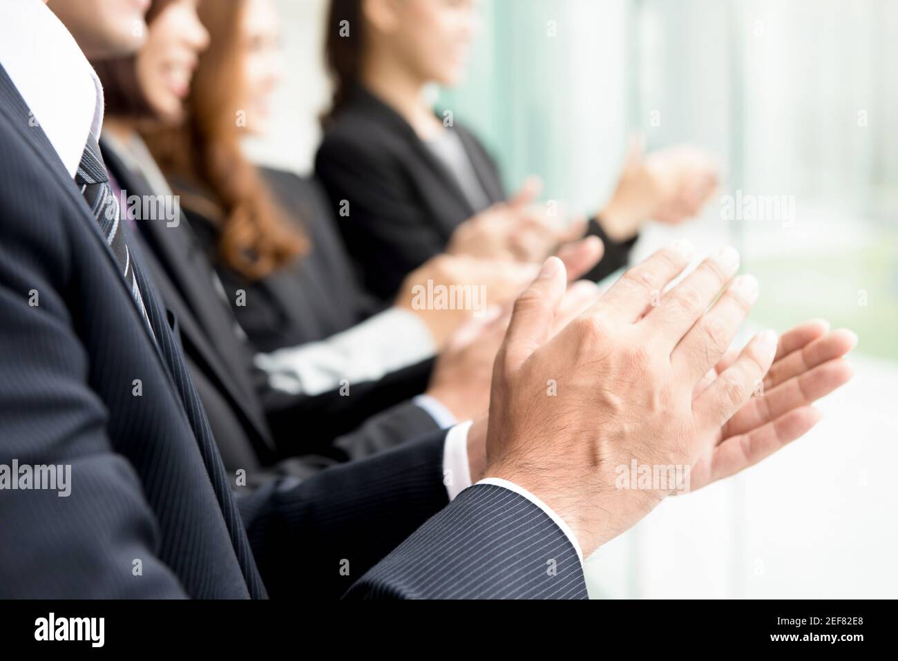 Gruppe von Geschäftsleuten, die in der Sitzung Beifall geben Stockfoto