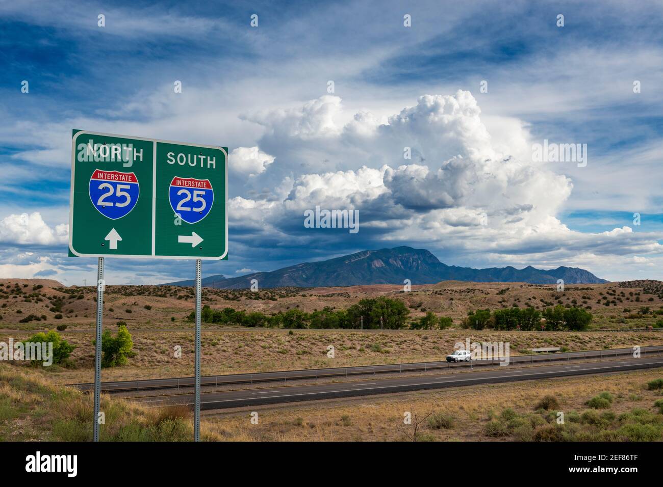 Blick auf die Interstate 25 im Bundesstaat New Mexico, mit Straßenschild und Bergen im Hintergrund. Stockfoto