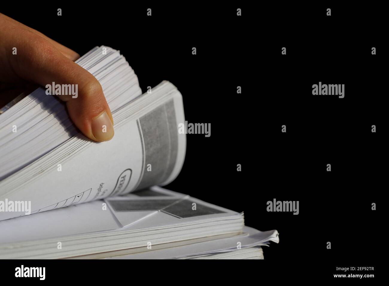 Die menschliche Hand dreht sich durch die Seiten des Ausdrucks. Stockfoto