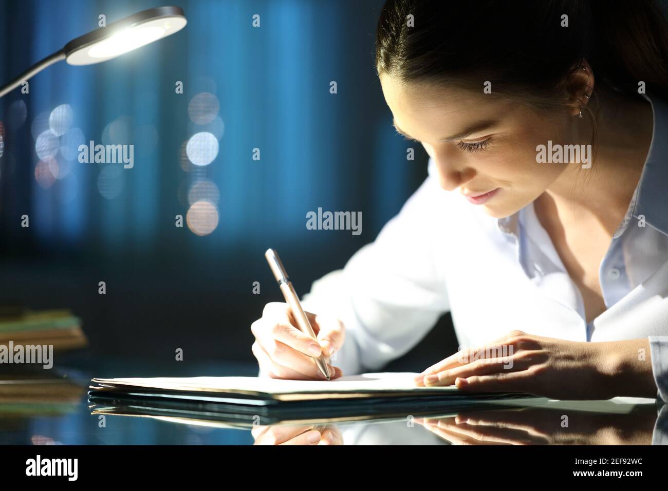 Frau füllt Papier Formular spät in der Nacht um Büro Stockfoto