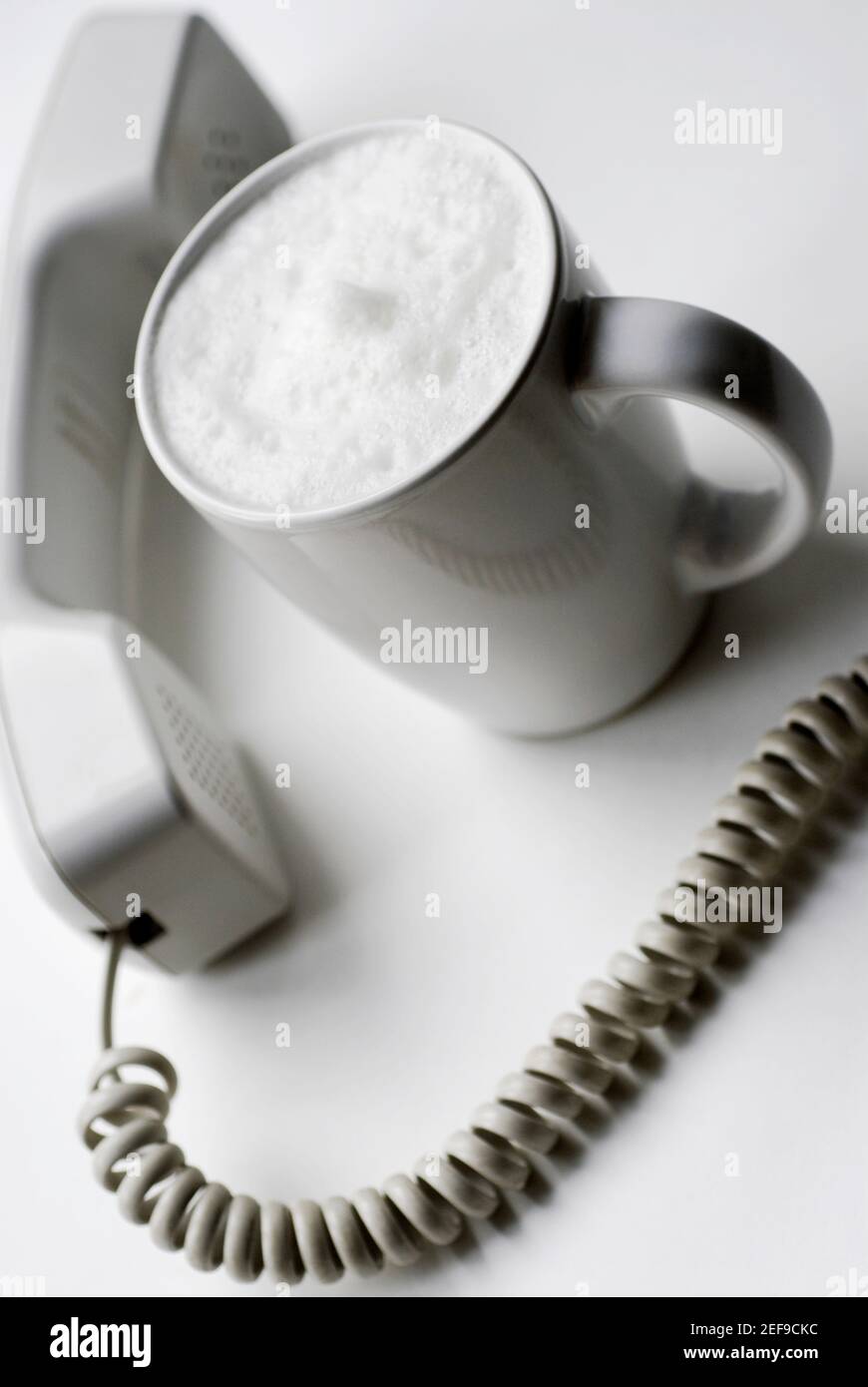 High-Angle-Ansicht einer Kaffeetasse mit Telefon Empfänger Stockfoto
