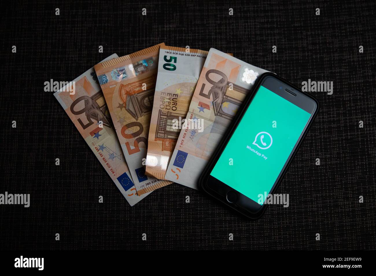 Ein Smartphone mit dem Whatsapp Pay Logo neben vier € 50 Rechnungen. Mit WhatsApp Pay können Sie direkt über die Messaging-App bezahlen und Geld senden Stockfoto