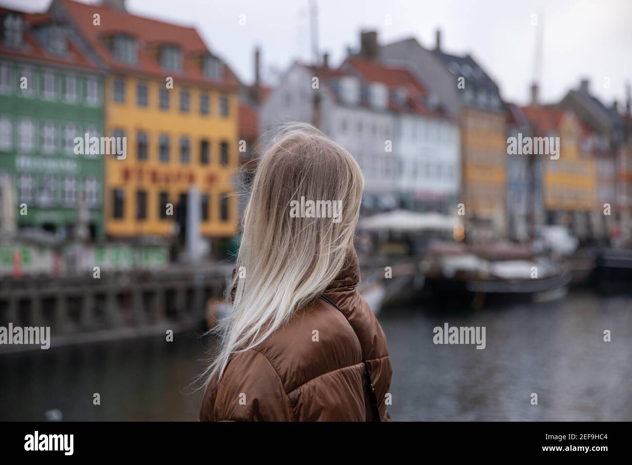 Nahaufnahme eines Mädchenkopfes von hinten und Blick auf die bunten Häuser in Nyhavn in Kopenhagen, Dänemark Stockfoto