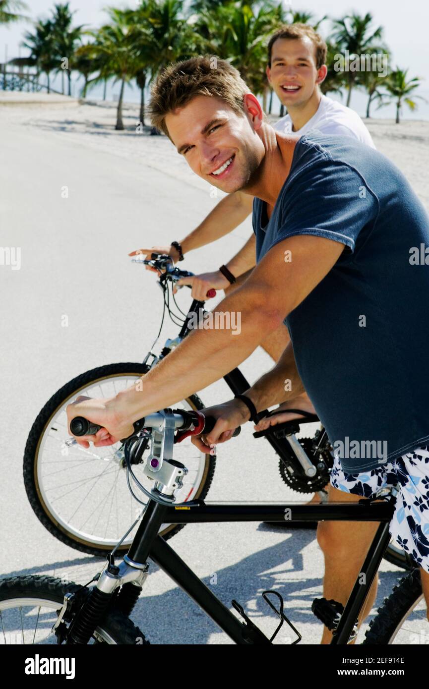Porträt zweier junger Männer auf Fahrrädern Stockfoto